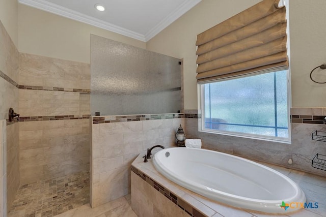 bathroom with crown molding, tile walls, walk in shower, and a garden tub