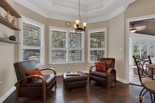 living area with dark wood-type flooring, baseboards, crown molding, and ceiling fan with notable chandelier