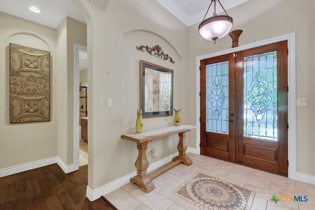 entryway with arched walkways, baseboards, french doors, and wood finished floors