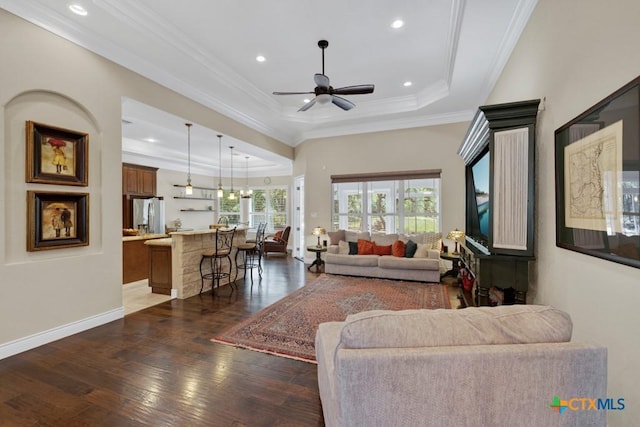 living room featuring recessed lighting, ceiling fan, a tray ceiling, and dark wood finished floors