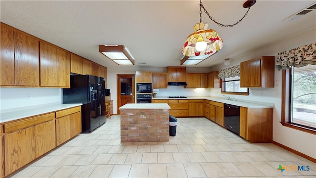 kitchen featuring sink, a kitchen island, and black appliances