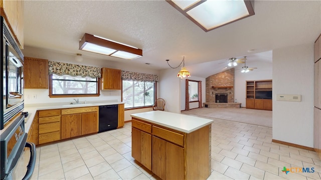 kitchen featuring a kitchen island, pendant lighting, lofted ceiling, black appliances, and a brick fireplace