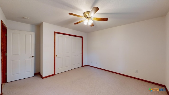 unfurnished bedroom with ceiling fan, light colored carpet, and a closet