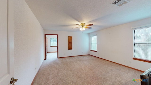 carpeted empty room with ceiling fan and a textured ceiling