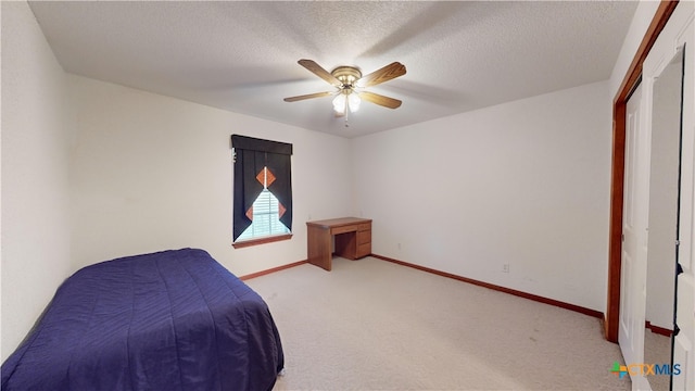 carpeted bedroom with ceiling fan and a textured ceiling