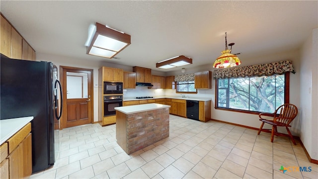 kitchen with a kitchen island, pendant lighting, ventilation hood, sink, and black appliances