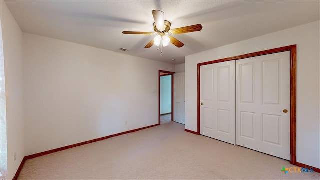 unfurnished bedroom featuring light carpet, a closet, and ceiling fan