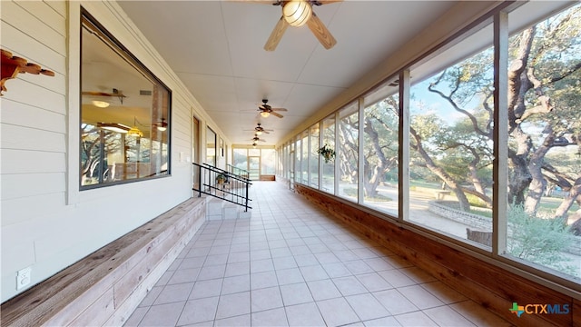 unfurnished sunroom featuring plenty of natural light and ceiling fan