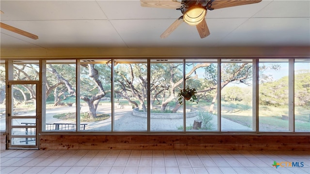 unfurnished sunroom featuring plenty of natural light and ceiling fan