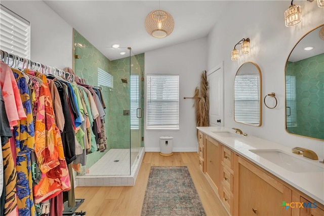 bathroom with vanity, lofted ceiling, wood-type flooring, and a shower with door