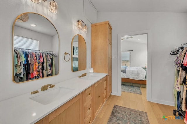 bathroom featuring vanity, vaulted ceiling, and hardwood / wood-style flooring