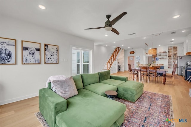 living room with ceiling fan and light wood-type flooring