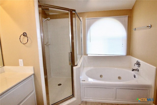 bathroom featuring vanity and independent shower and bath