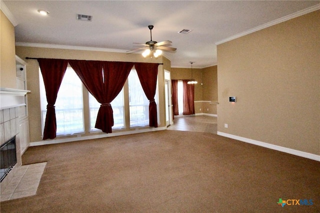 unfurnished living room featuring ceiling fan with notable chandelier, crown molding, a tile fireplace, and light carpet