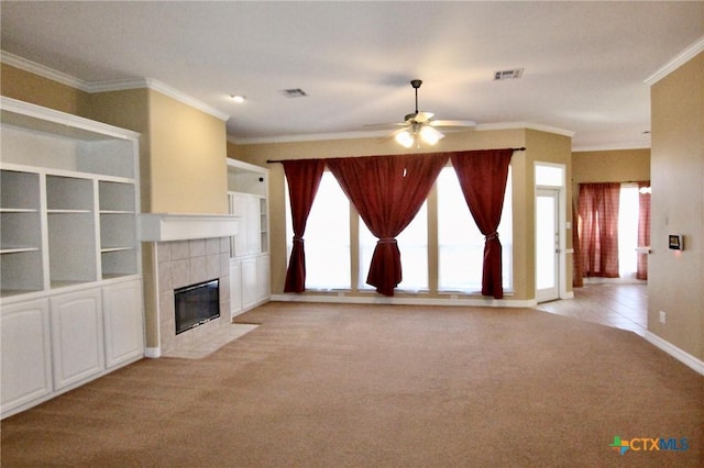 unfurnished living room with a tile fireplace, light colored carpet, a healthy amount of sunlight, and ornamental molding