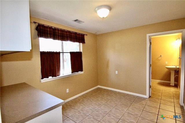 unfurnished room featuring light tile patterned floors and sink