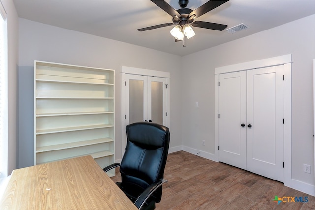 home office with hardwood / wood-style flooring and ceiling fan