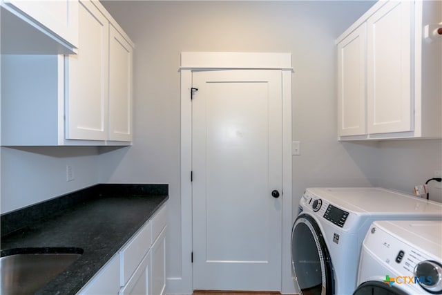 laundry room with washer and clothes dryer, cabinets, and sink