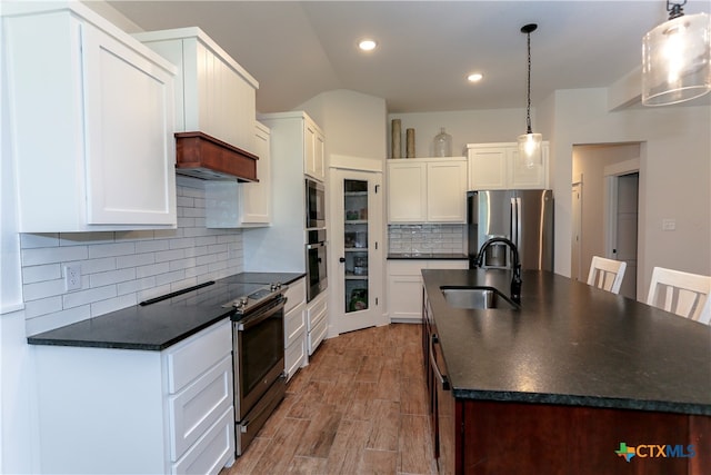 kitchen featuring white cabinetry, stainless steel appliances, and hanging light fixtures