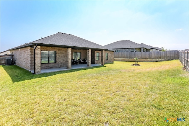 rear view of house with a yard and a patio area