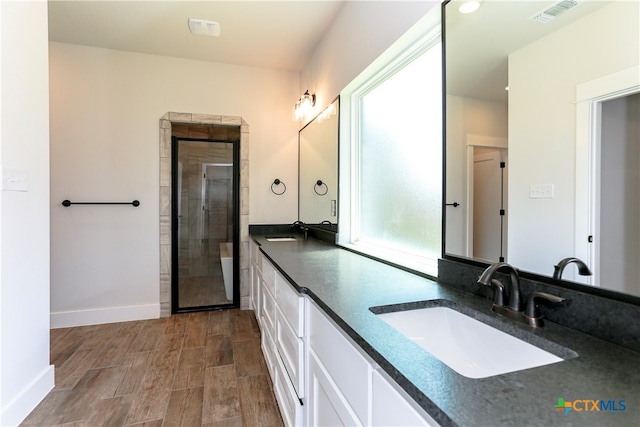 bathroom featuring vanity and a shower with door