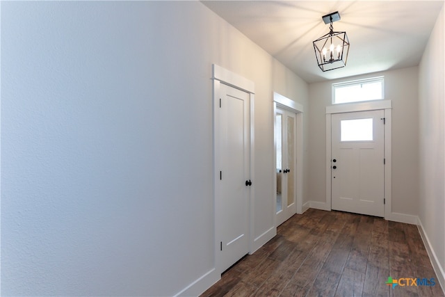 entrance foyer featuring dark hardwood / wood-style floors and an inviting chandelier