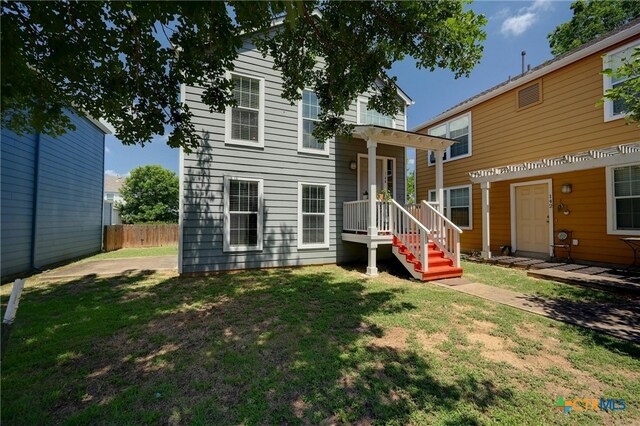 rear view of house featuring a yard