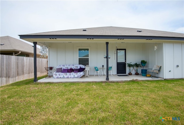 back of house with a patio area and a lawn