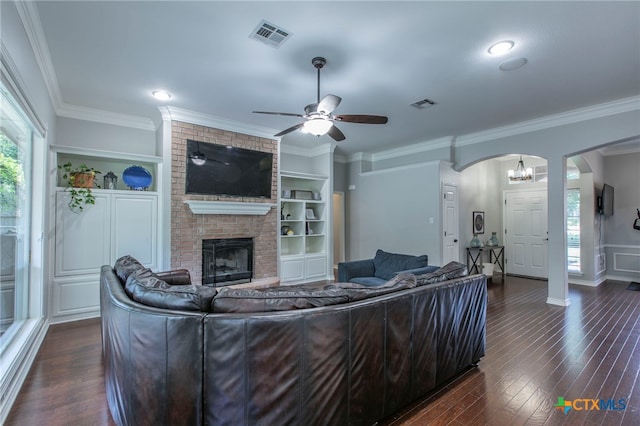 11503 Meredith Dr, Belton, TX 76513 - living room featuring arched walkways, ceiling fan, crown molding, dark wood-style flooring, and a brick fireplace