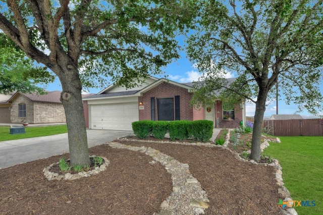 single story home featuring an attached garage, concrete driveway, a front lawn, and brick siding