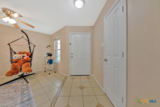 entrance foyer featuring light tile patterned flooring, baseboards, and ceiling fan