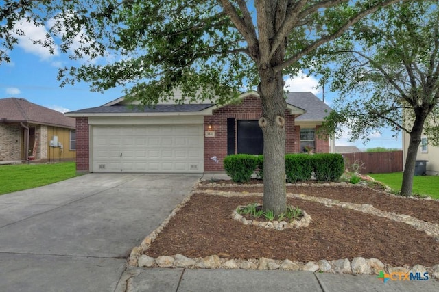 ranch-style house with fence, a front lawn, brick siding, a garage, and driveway