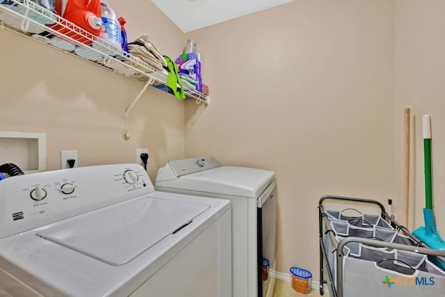 washroom featuring baseboards, laundry area, and washer and clothes dryer