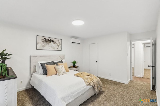 bedroom with a wall mounted AC and dark colored carpet