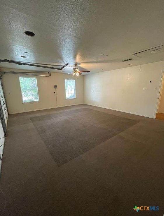 empty room with ceiling fan, carpet flooring, and a textured ceiling