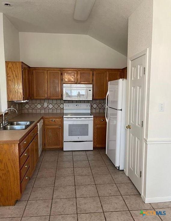 kitchen with vaulted ceiling, sink, decorative backsplash, light tile patterned floors, and white appliances