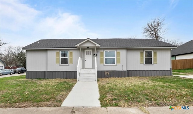 manufactured / mobile home featuring fence and a front lawn