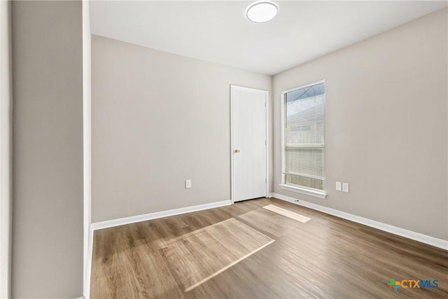 unfurnished room with wood-type flooring