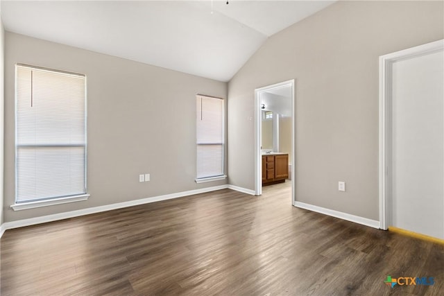 empty room with dark hardwood / wood-style floors and lofted ceiling