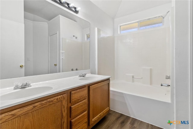 bathroom with lofted ceiling, wood-type flooring, vanity, and bathing tub / shower combination