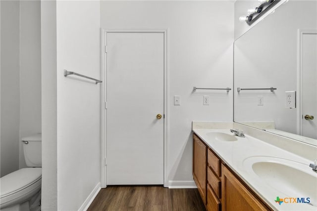 bathroom with vanity, toilet, and wood-type flooring