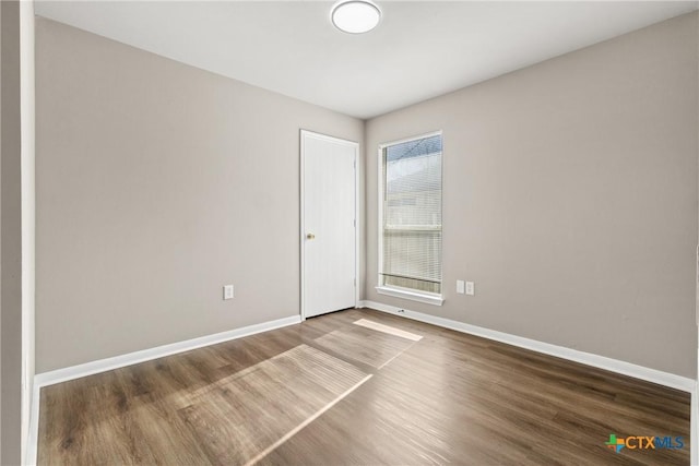 unfurnished room with dark wood-type flooring