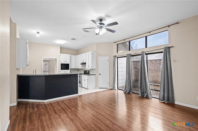 kitchen featuring a ceiling fan, baseboards, white cabinets, stainless steel electric stove, and dark wood-style floors