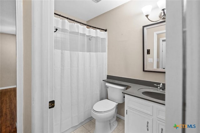 bathroom featuring toilet, tile patterned flooring, vanity, and baseboards