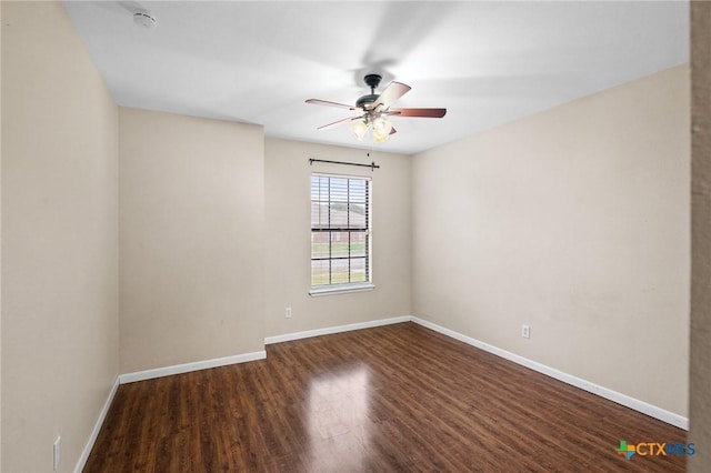 unfurnished room with dark wood-style floors, a ceiling fan, and baseboards