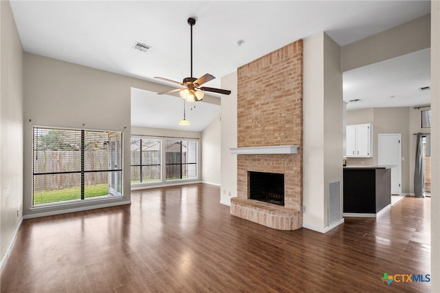 unfurnished living room with dark wood-style floors, a fireplace, and visible vents