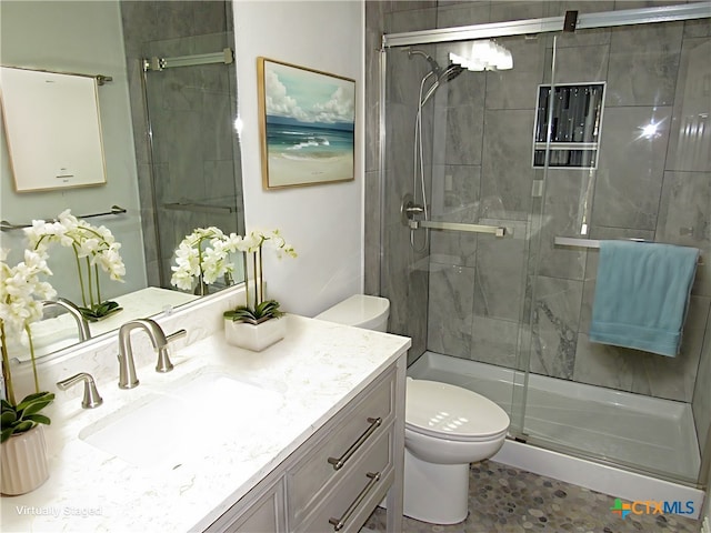 full bath featuring a shower stall, vanity, and toilet