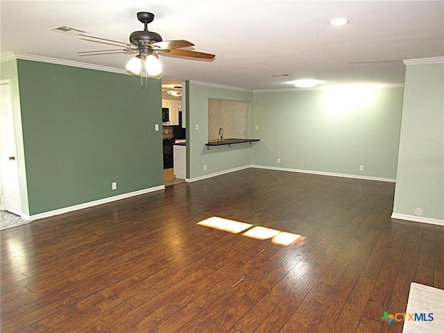 unfurnished living room with dark wood-style floors, visible vents, crown molding, and baseboards