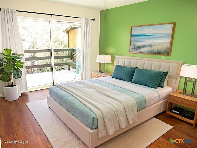 bedroom featuring access to exterior, multiple windows, and dark wood-type flooring