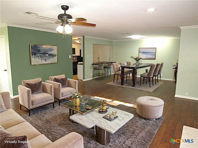 living area featuring dark wood finished floors, crown molding, visible vents, ceiling fan, and baseboards